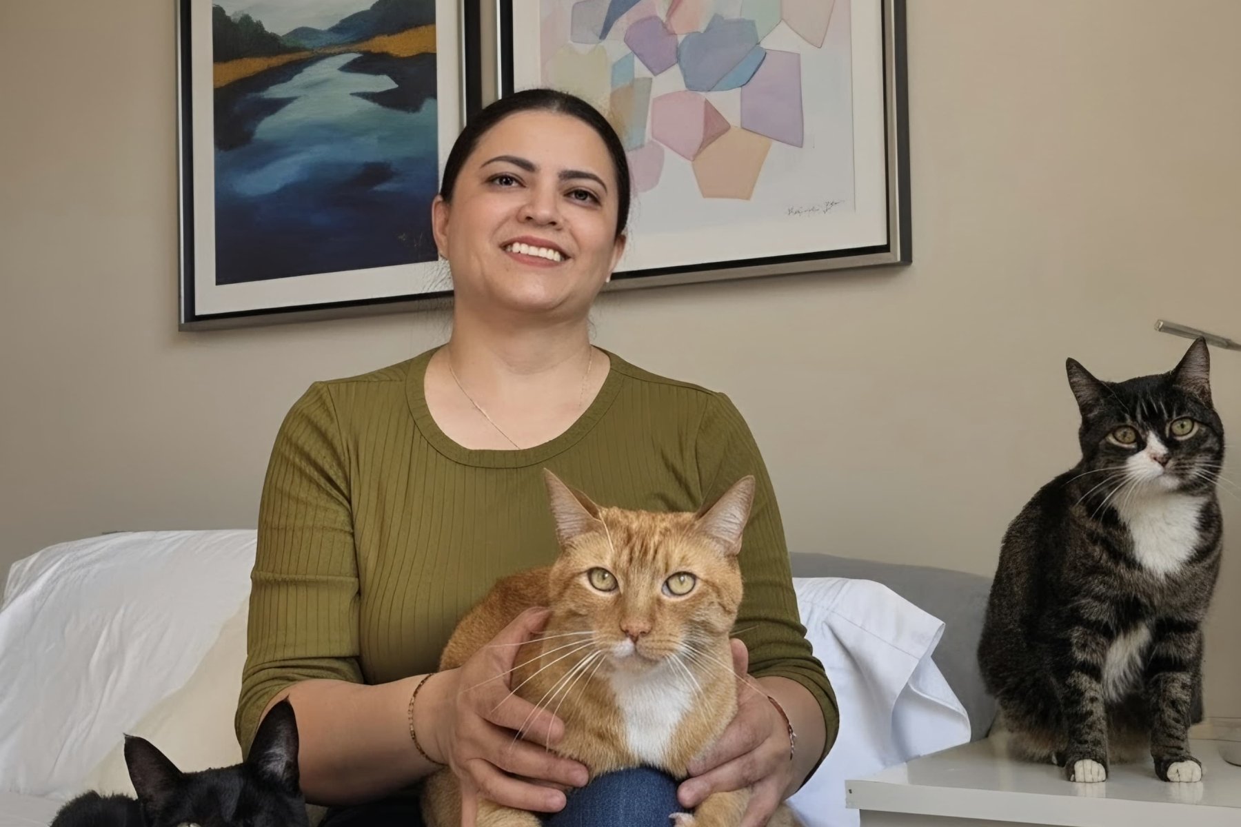 Yoselyn, our groomer, smiling with three cats